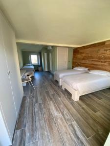 1 dormitorio con 2 camas y suelo de madera en AFFITTACAMERE VAL SUSA, en San Didero 