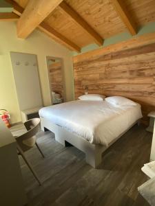 1 dormitorio con 1 cama grande y cabecero de madera en AFFITTACAMERE VAL SUSA, en San Didero 