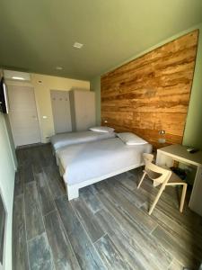 een slaapkamer met 2 bedden en een houten muur bij AFFITTACAMERE VAL SUSA in San Didero 