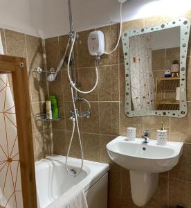 y baño con ducha, lavabo y espejo. en Cozy and Clean Apartment, near National Arena, en Bucarest