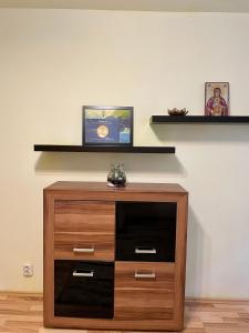 a wooden cabinet with a shelf on a wall at Cozy and Clean Apartment, near National Arena in Bucharest
