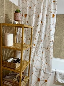 a bathroom with a shower curtain and a shelf with towels at Cozy and Clean Apartment, near National Arena in Bucharest