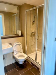 a bathroom with a shower and a toilet and a sink at XL Corner Apartment w Gym & Spa in Manchester