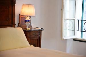 1 dormitorio con 1 cama y 1 lámpara en una mesa en La Terrazza di Vico Olivi B&B, en Ventimiglia