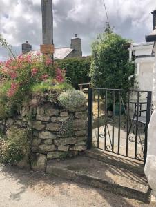 una pared de piedra con una puerta delante de una casa en Cosy Cottage Real Fire Nearby Pub Garden Parking, en Altarnun