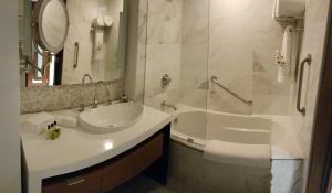 a bathroom with a sink and a tub and a mirror at Real Intercontinental Metrocentro Managua, an IHG Hotel in Managua
