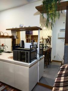 a kitchen with a black microwave on a counter at SwissBelResidence Studio With King Bed in Kuantan