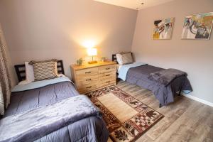 a bedroom with two beds and a dresser in it at Pinetop Nest: Happy Place in Sugar Mountain in Banner Elk