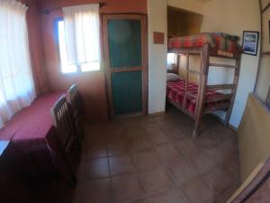 um pequeno quarto com 2 beliches e uma janela em Andoriña Hostal - Bed & Breakfast em Samaipata