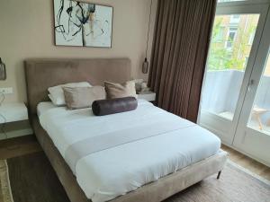 Un dormitorio con una cama grande con una almohada. en New stylish 1 bedroom apt w/ 2 balconies in Centrum, en Ámsterdam