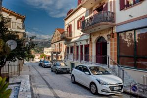 une voiture blanche garée sur le côté d'une rue dans l'établissement Nikola's & Joanna's apartments 2, à Argostóli