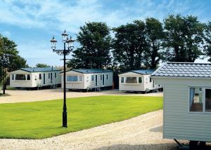 a row of mobile homes in a park with a light pole at St Cyrus Park in Montrose