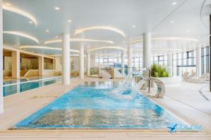 a large pool with a fountain in a building at Aqua Polanki Bodnar Apartments in Kołobrzeg