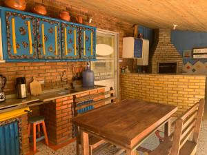 cocina con mesa de madera y pared de ladrillo en Villa Do Mar, en Palhoça