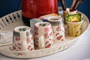 una bandeja con tazas y otros artículos sobre una mesa en PARASIOU STUDIOS 107 διαμερίσματα στο κέντρο της πόλης, en Komotiní