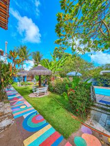 a path painted in the grass next to a pool at Chalés Caiçara Serrambi in Porto De Galinhas