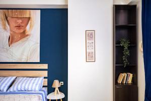 un dormitorio con una pared azul con una foto de una mujer en PARASIOU STUDIOS 107 διαμερίσματα στο κέντρο της πόλης, en Komotiní