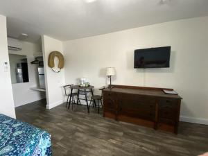 a bedroom with a bed and a flat screen tv on a wall at Wachapreague Inn - Motel Rooms in Wachapreague