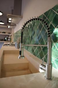 a kitchen sink with a metal faucet at 3B Wellness Hostel in Playa del Carmen