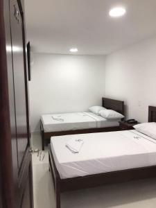 Habitación con 3 camas en una habitación en Hotel Plaza Berlín, en Medellín