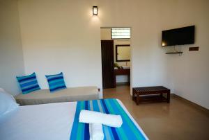 ヤーラにあるRanakeliya Lodge - Yalaのベッドとテレビ付きのホテルルーム