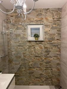 a bathroom with a stone wall with a picture on it at Vila Kata in Zubovići