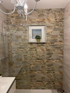 a bathroom with a stone wall with a picture on it at Vila Kata in Zubovići +37 photos
