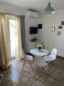 a living room with a table and chairs and a television at Vila Kata in Zubovići