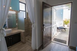 a bathroom with a shower and a sink and a mirror at Posada Mariposa Boutique Hotel - 5th Avenue in Playa del Carmen