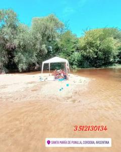 a tent on a beach in the middle of a river at HARD ROCK SERRANO in Santa María