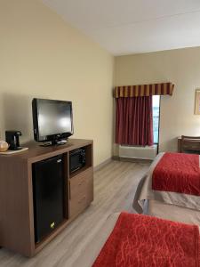 Econo Lodge في نيوبورت: غرفة فندقية بسرير وتلفزيون بشاشة مسطحة