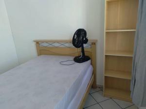 ein Schlafzimmer mit einem Bett und einem Ventilator in der Unterkunft HELBOR ATLANTIS (PÉ NA AREIA) in Bertioga
