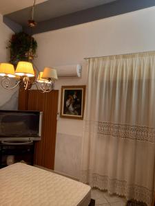Cianciana的住宿－D'ALTRITEMPI-Elegance in Cianciana.，一间带电视和窗帘的客厅