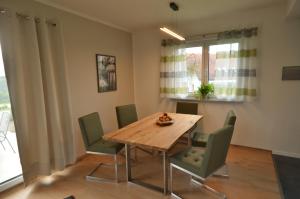 uma sala de jantar com uma mesa de madeira e cadeiras em Ferienhaus TonArt em Nestelbach bei Graz