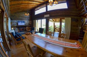 a large wooden table in a room with a large window at LA LINDA - Cabaña de Montaña in Villa Berna