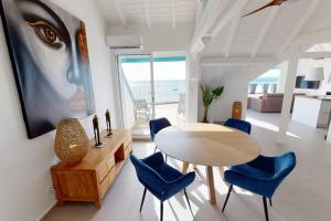 a dining room with a table and blue chairs at Walee Beach Penthouse by the sea, 2 bedrooms, pool in Saint Martin
