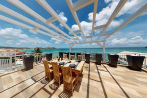 einen Balkon mit einem Tisch, Stühlen und Meerblick in der Unterkunft Walee Beach Penthouse by the sea, 2 bedrooms, pool in Saint Martin