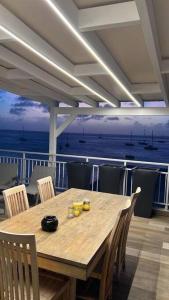 una mesa de madera y sillas con vistas al océano en Walee Beach Penthouse by the sea, 2 bedrooms, pool, en Saint Martin