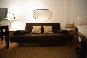 a couch with two pillows sitting in a living room at Sebino Guest House in Milan