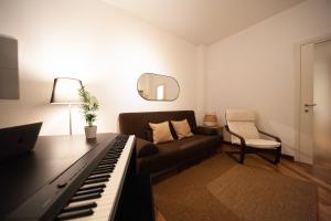 salon z pianinem i kanapą w obiekcie Sebino Guest House w Mediolanie