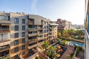 un edificio de apartamentos con un patio frente a él en Apartamentos Arcoíris en Granada