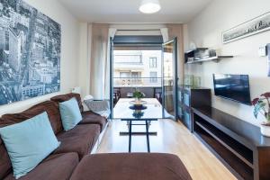 uma sala de estar com um sofá e uma mesa em Apartamentos Arcoíris em Granada