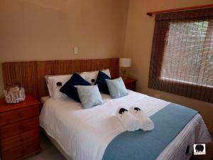1 dormitorio con 1 cama con 2 zapatillas en Mazi Vuwu Ponta Malongane, en Ponta do Ouro