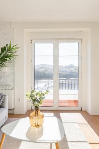 a living room with a table and a large window at LA CASA DEL RELOJ in Luanco