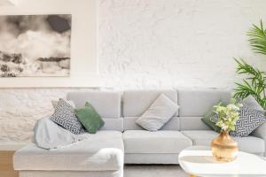 a living room with a couch with pillows on it at LA CASA DEL RELOJ in Luanco