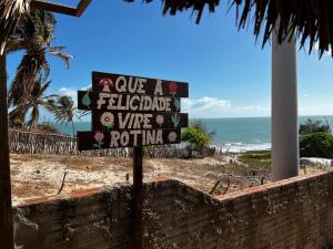 un cartel frente a una playa con el océano en Beach Place Fontainha en Aracati