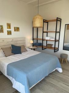 1 dormitorio con 1 cama grande con manta azul en Altamar Casas de Playa, en La Paloma