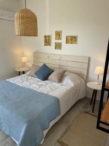 1 cama en un dormitorio con 2 mesas y 2 lámparas en Altamar Casas de Playa, en La Paloma