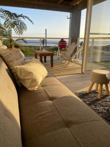 un sofá en la sala de estar con vistas al océano en Altamar Casas de Playa, en La Paloma