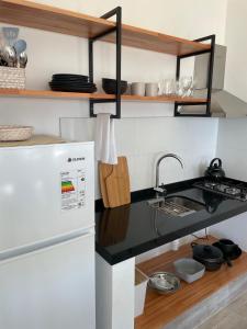 cocina con fregadero y nevera en Altamar Casas de Playa, en La Paloma